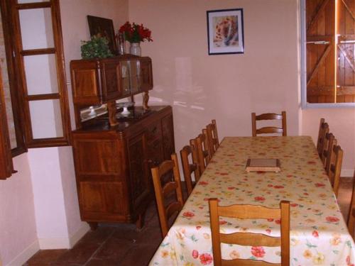 a dining room with a table with chairs and a cabinet at La Plaine in Puygaillard-de-Quercy