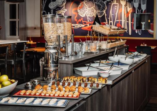 una línea de buffet con bollería y otros productos alimenticios en Grimms Hotel Hanau, en Hanau am Main
