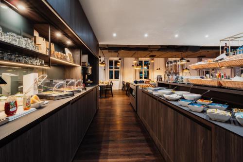 un restaurante con una larga fila de mostradores con comida en Grimms Hotel Hanau, en Hanau am Main