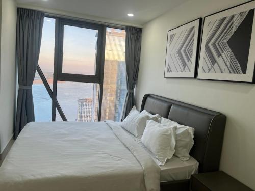 Un dormitorio con una cama con una ventana grande. en The Peak Residence Service Apt By Hayden, en Phnom Penh