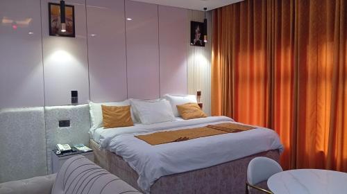 una habitación de hotel con una cama y un sofá en Uptown Life Hotel and Suites, en Warri