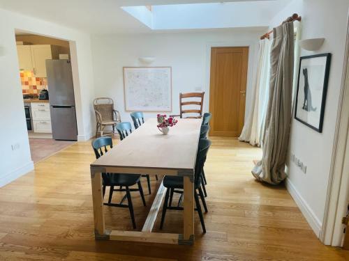 ein Esszimmer und eine Küche mit Tisch und Stühlen in der Unterkunft Cotswolds Eco House in Charlbury