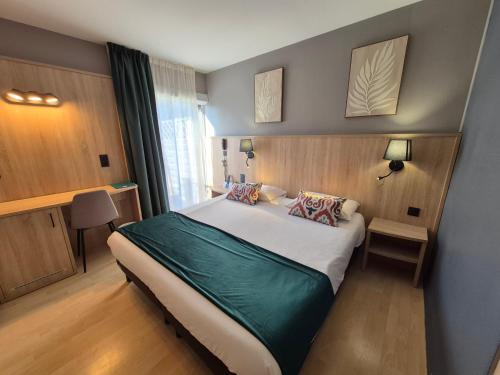 a bedroom with a large bed in a room at Logis Hotel Les Gravades Ussel in Ussel