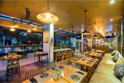 a restaurant with tables and chairs and a bar at Palette Legian Beach in Legian