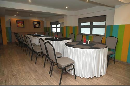 una fila de mesas y sillas en una habitación en Classy Stay Sagar Inn Hadapsar Rooms Banquet Restaurant & Bar, en Pune