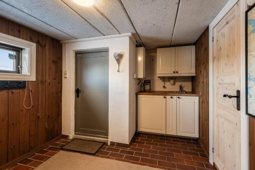 une cuisine avec une porte menant à une cuisine avec un comptoir dans l'établissement Large cabin with spectacular views in Geilo, à Geilo
