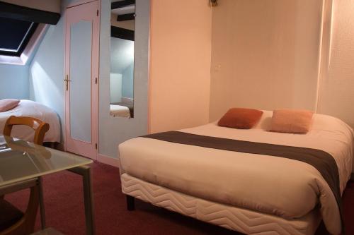 a bedroom with a bed with orange towels on it at Cit'Hotel Hôtel Beauséjour in Cherbourg en Cotentin