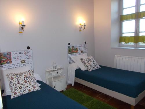 a bedroom with two beds and a window and two lamps at Gîte Communal "Ecole" in Montain
