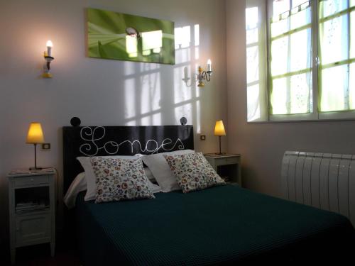 a bedroom with a green bed with two windows at Gîte Communal "Ecole" in Montain