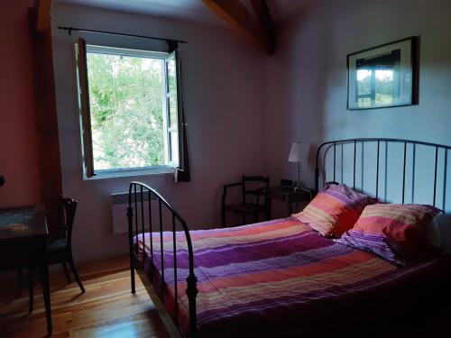 Ένα ή περισσότερα κρεβάτια σε δωμάτιο στο Le Moulin du Pont de Matar