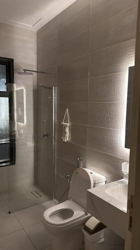 a bathroom with a shower and a toilet and a sink at Elegant and classy apartment in Al Faisaliah neighborhood in Jeddah