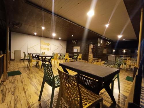 a dining room with tables and chairs in a room at Hotel River Point in Malvan