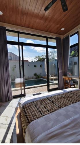 a bedroom with a bed and a large window at Pondok Murni Mesari in Mantaak