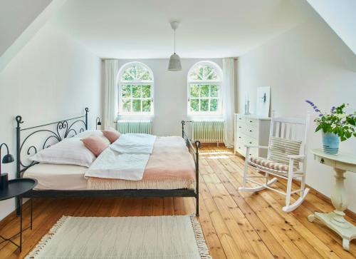 une chambre avec un lit et un bureau et deux fenêtres dans l'établissement Stylish Apartment In A Historic Country House, à Meezen