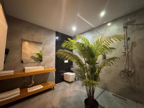 a bathroom with a shower and a plant in it at Marina Boutique Hotel Istanbul Airport in Karaburun