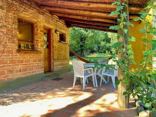 a patio with a table and chairs in a building at Cabaña Paihuen in Villa General Belgrano