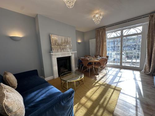 a living room with a blue couch and a table at Queens Terrace Apartments in Exeter