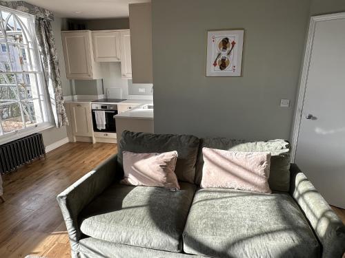 a living room with a couch and a kitchen at Queens Terrace Apartments in Exeter
