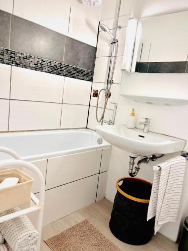 a white bathroom with a sink and a bath tub and a sink at Ferienwohnung Lona in Bad Reichenhall