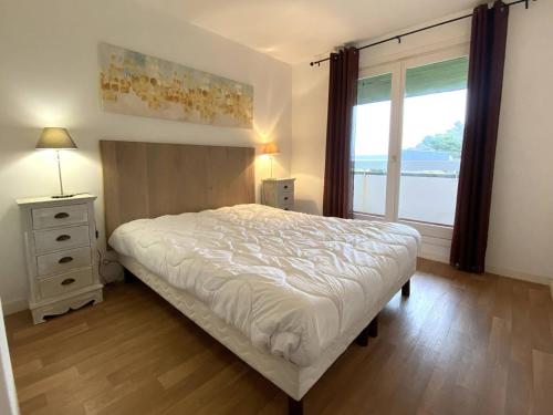 a bedroom with a white bed and a window at Appartement 3* avec terrasse et parking, à 2 pas de la plage de Trestraou à Perros-Guirec - FR-1-368-244 in Perros-Guirec