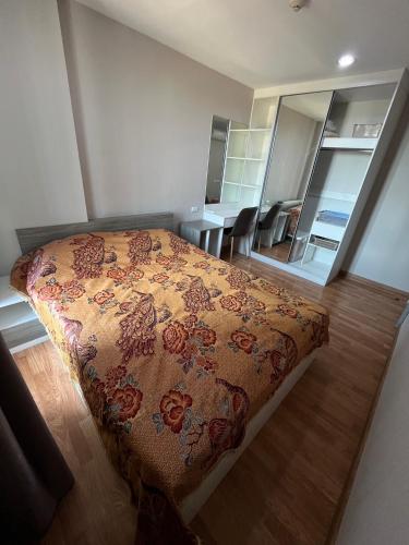 een slaapkamer met een bed met een bloemendeken bij AC Home 1 Laksi in Lak Si