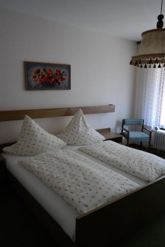 a bed with white sheets and pillows in a bedroom at Herzog's Ulsterbrücke in Tann