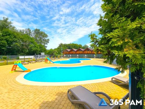 une grande piscine avec deux toboggans et une aire de jeux dans l'établissement 365PAM - Studio Białe i Czarne w Dominikanie Przy Morzu, à Sianożęty