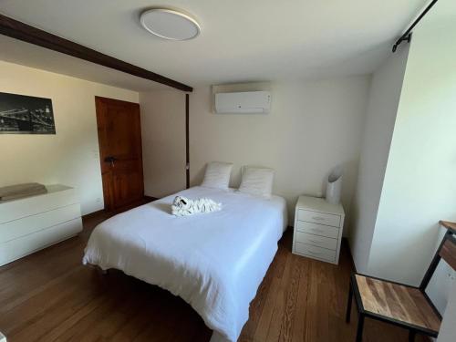 - un chat dormant sur un lit blanc dans une chambre dans l'établissement Domaine Cherps Spa - Zen, à Vielleségure