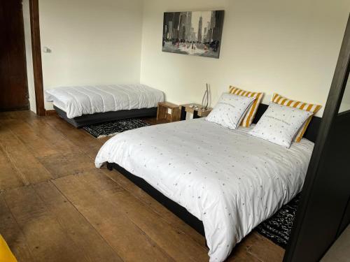 une chambre avec deux lits avec des draps blancs dans l'établissement Domaine Cherps Spa - Sérénité, à Vielleségure