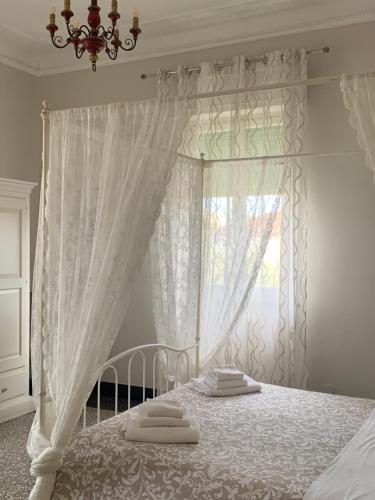 une chambre avec un lit blanc avec une fenêtre dans l'établissement Villa Catelli, à Lucques
