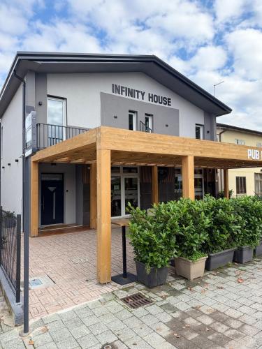 a building with a wooden pergola in front of it at Infinity House - Eleganza Moderna tra Treviso e Venezia in Casièr