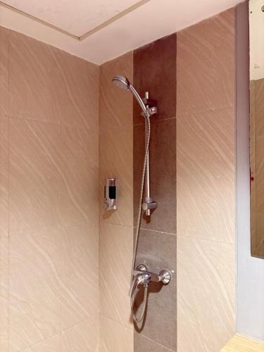 a shower with a shower head in a bathroom at Cozy Bogor Icon Studio Apt bogor W Pool in Kedunghalang