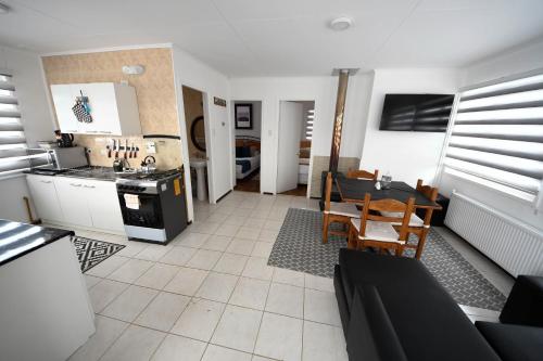 纳塔列斯港Cabañas Terravento的配有桌椅的厨房和客厅