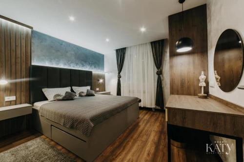 a bedroom with a large bed and a mirror at Apartman KATY in Vukovar