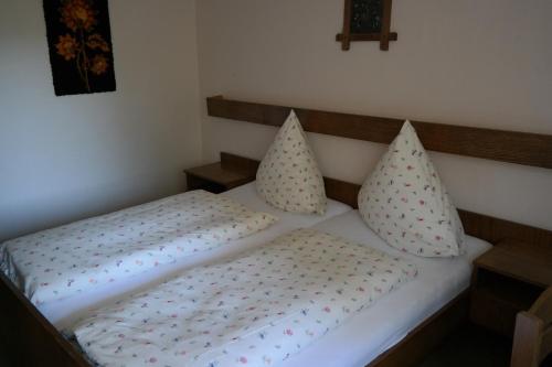a bedroom with a bed with pillows on it at Herzog's Ulsterbrücke in Tann