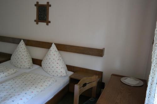 a small bedroom with a bed and a wooden table at Herzog's Ulsterbrücke in Tann