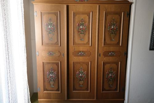 a wooden cabinet with flowers on it in a room at Herzog's Ulsterbrücke in Tann