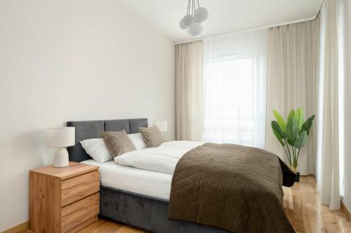 a bedroom with a large bed and a window at Luxury Apartment with Parking & Terrace Remote Work by Renters Prestige in Poznań