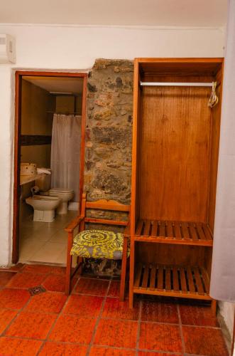 a bathroom with a toilet and a bench at Hotel La Mision in Colonia del Sacramento