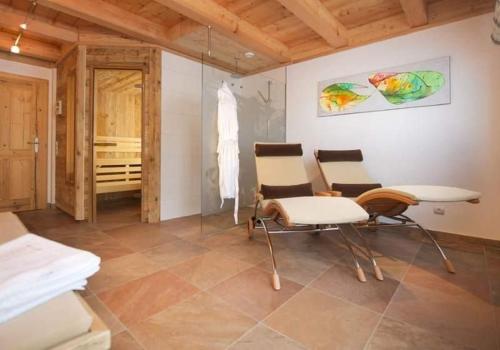 a room with two chairs and a table and a bedroom at Ferienhaus Wallegg Lodge In Saalbach Hinterglemm in Saalbach Hinterglemm