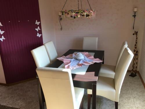 une salle à manger avec une table noire et des chaises blanches dans l'établissement Gemütliches Ferienhaus In Godow Mit Terrasse, à Kargow