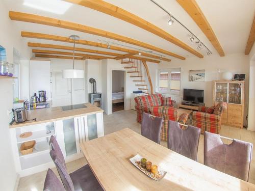 une cuisine et un salon avec une table et des chaises dans l'établissement Ferienhaus Mit Atemberaubendem Blick Auf Den See, à Wiefelstede