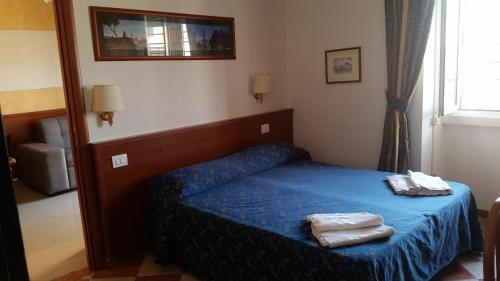 een slaapkamer met een blauw bed met 2 handdoeken erop bij Filiberto Apartment in Rome