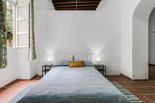 a bed in a room with two lamps and a window at Lovely Stay Arucas in Arucas