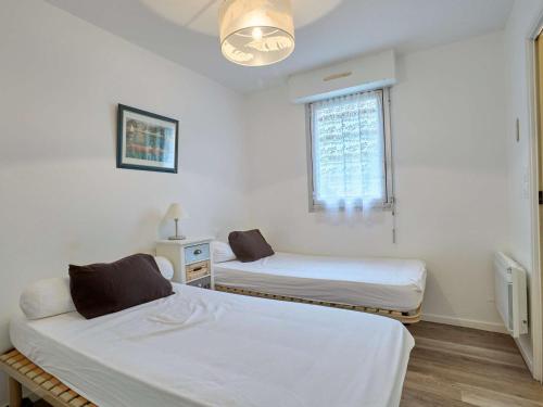 a room with two beds and a window at T2 cosy, jardinet, animaux admis, parking et WiFi - FR-1-841-35 in Barbotan-les-Thermes