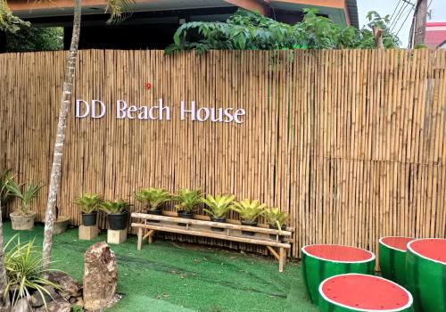 a wooden fence with a bench in front of a house at DD Beach Houses in Phra Ae beach