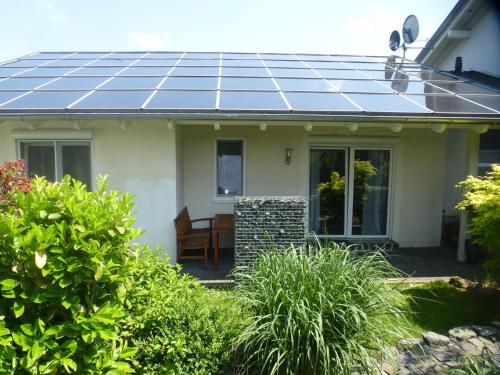 ein Haus mit Sonnenkollektoren auf dem Dach in der Unterkunft Ferienhaus für sieben Personen mit überdachter Terrasse - a82656 in Friedrichshausen