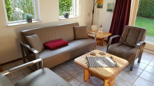 a living room with a couch and a table and chairs at Gemütliches Haus Mit Komplett Umzäuntem Garten in Wemeldinge