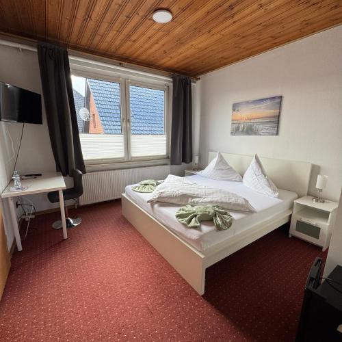 a small bedroom with a bed and a window at Hotel-Restaurant Christine in Lübz