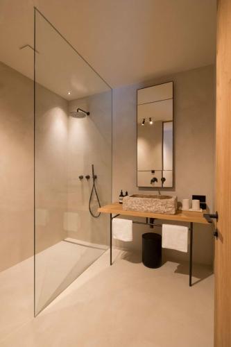 a bathroom with a shower and a table with a mirror at Design Apartment Carina in Lech am Arlberg